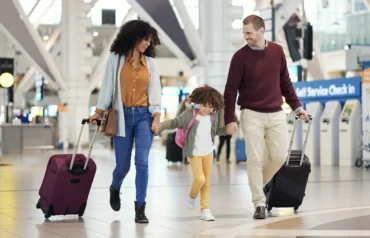 A crowded holiday airport terminal with travelers practicing safety measures and securing their luggage.